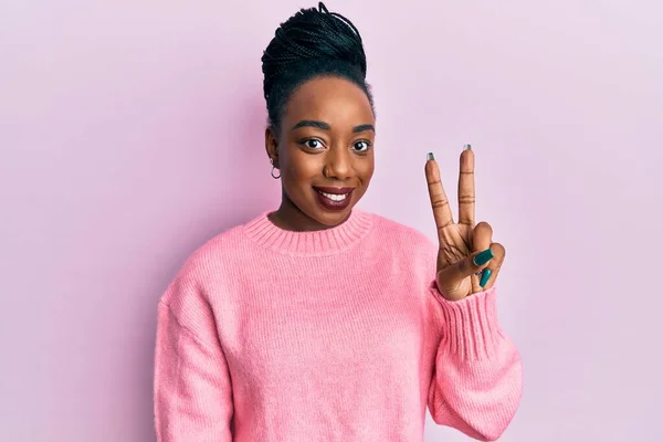 年轻的非洲裔美国女人穿着休闲地冬季毛衣 手指头一指二指 面带微笑 自信而快乐 — 图库照片