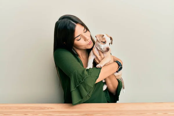 Joven Chica Hispana Abrazando Besando Perro Sentado Mesa Sobre Fondo — Foto de Stock