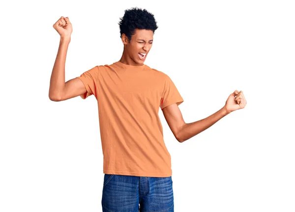 カジュアルな服を着た若いアフリカ系アメリカ人男性が幸せと陽気に踊り 笑顔でカジュアルで自信を持って音楽を聴く — ストック写真