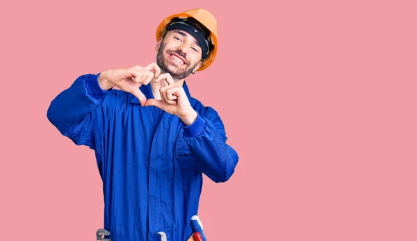 Joven Hombre Hispano Vistiendo Uniforme Obrero Sonriendo Amor Haciendo Forma —  Fotos de Stock