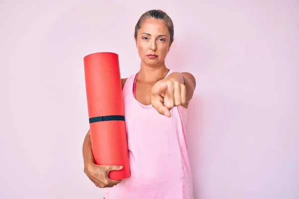 Orta Yaşlı Spanyol Kadın Yoga Minderini Tutarak Kamerayı Işaret Ediyor — Stok fotoğraf