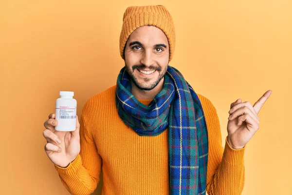 Молодий Іспаномовний Чоловік Зимовому Одязі Тримає Таблетки Посміхаючись Щасливим Вказуючи — стокове фото