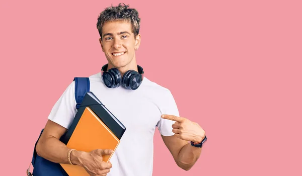 Joven Hombre Guapo Sosteniendo Mochila Estudiante Libros Sonriendo Feliz Señalando —  Fotos de Stock