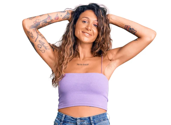 若いですヒスパニック女性でタトゥーを身に着けていますカジュアル服リラックスしてストレッチ 腕と手頭と首の後ろに笑顔幸せ — ストック写真