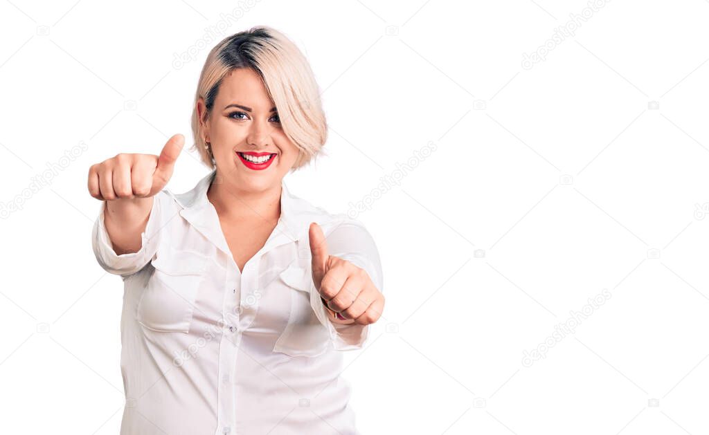 Young blonde plus size woman wearing casual shirt approving doing positive gesture with hand, thumbs up smiling and happy for success. winner gesture. 