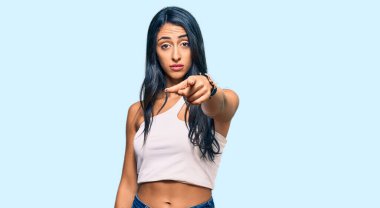 Güzel İspanyol kadın gündelik giysiler giyip kameraya kızgın ve sinirli bir şekilde seni işaret ediyor. 