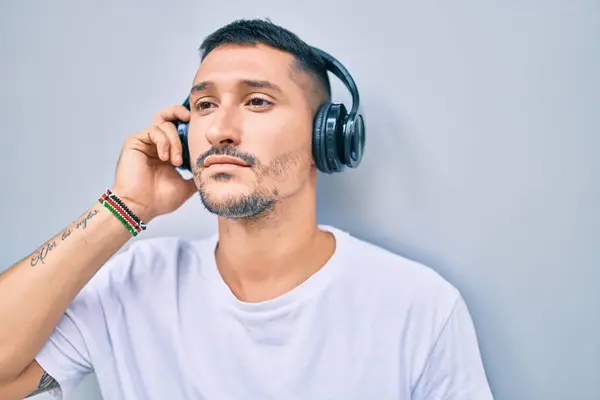Ung Latinamerikansk Man Ler Glad Lyssnar Musik Med Hörlurar Gatan — Stockfoto