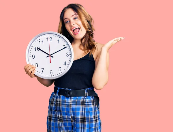 Joven Hermosa Mujer Caucásica Sosteniendo Gran Reloj Celebrando Victoria Con —  Fotos de Stock