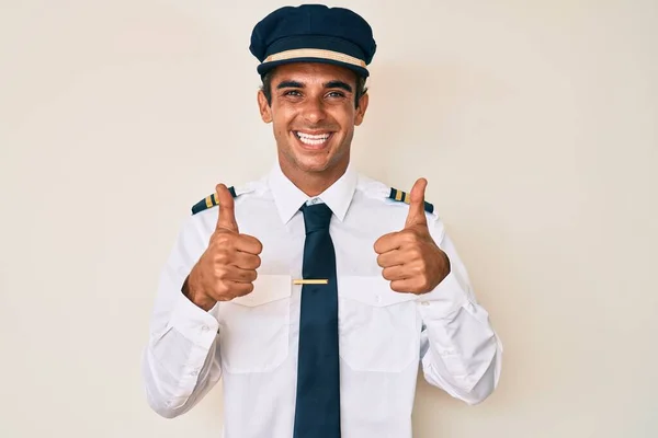 Mladý Hispánec Oblečený Uniformě Pilota Letadla Dělá Pozitivní Gesto Rukou — Stock fotografie