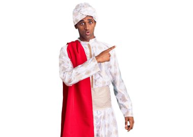 Gelenek giyinmiş Afrikalı yakışıklı bir adam Sherwani sari giysileri giyer. Yan tarafı göstererek şaşırır, ağzı açık şaşkın bir ifade sergiler.. 