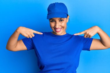 Güzel esmer kadın teslimat üniforması giyiyor. Kendine güveni tam görünüyor. Kendini gururlu ve mutlu gösteriyor.. 