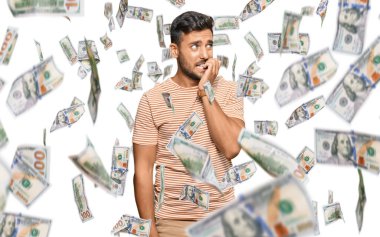 Günlük kıyafetler giyen yakışıklı, gergin ve gergin görünen, elleri ağızdan tırnak yiyen bir İspanyol. anksiyete.