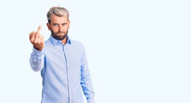 Young handsome blond man wearing elegant shirt showing middle finger, impolite and rude fuck off expression 