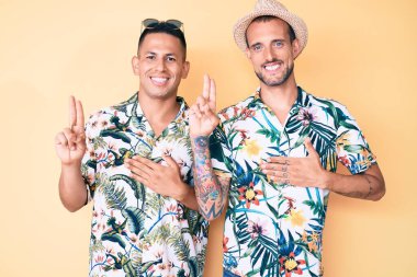 Yaz şapkası ve Hawaii tişörtü giyen iki genç eşcinsel el pençe divan durup, sadakat yemini ediyorlar. 