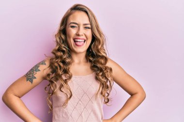 Sıradan kıyafetler giyen genç sarışın kız komik bir ifadeyle dilini dışarı çıkartıyor. duygu kavramı. 