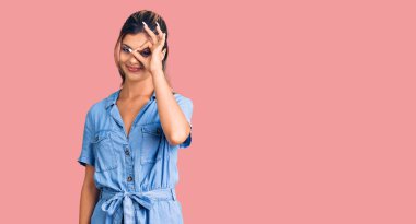 Genç ve güzel bir kadın günlük kıyafetler giyiyor. El hareketleriyle gülümsüyor, gözleriyle mutlu yüzlere bakıyor.. 