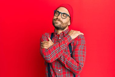 Yakışıklı, sakallı, hippi görünümlü, kendine sarılan mutlu ve pozitif, kendine güvenen bir adam. Sevgi ve özgüven. 