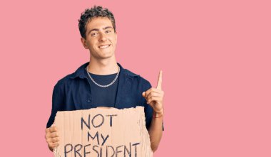 Elinde başkanımın protesto pankartı olmayan yakışıklı adam bir fikir ya da soruyla şaşırdı ve mutlu bir yüzle işaret etti. 