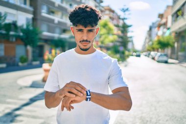 Genç Arap adam gülümsüyor Şehrin caddesinde mutlu bir şekilde yürüyor.