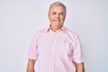 Yaşlı, gri saçlı, sıradan kıyafetler giyen mutlu ve havalı bir gülümsemesi olan bir adam. şanslı kişi. 