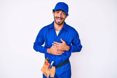 Kıvırcık saçlı ve ayı gibi giyinen yakışıklı genç adam gülümseyerek kahkahalarla gülüyor.. 