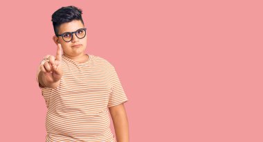 Little boy kid wearing casual clothes and glasses pointing with finger up and angry expression, showing no gesture 