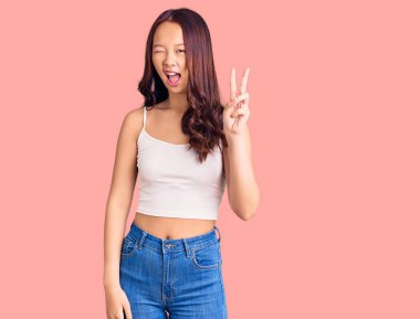 Genç, güzel, sıradan kıyafetler giyen, gülümseyen, kameraya göz kırpan, zafer işareti yapan Çinli bir kız. İki numara.. 