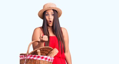 Yazlık şapka takan genç, güzel esmer kadın elinde piknik sepeti tutuyordu. Korkmuş ve şaşkına dönmüştü. 