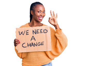 Genç Afrikalı Amerikalı kadın elinde bir değişim pankartı tutuyordu. Parmaklarıyla imza atıyor, gülümsüyordu. Mükemmel bir sembol. 