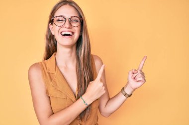 İş gömleği giyen, gözlüklü, sırıtan ve kahkahalarla gülen genç sarışın kız.. 