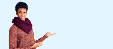 Sıradan bir kazak ve eşarp giyen genç Afro-Amerikan erkeği gülümseyerek içeri girmeye davet ediyor. 