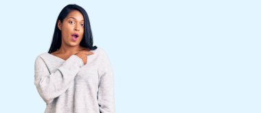 Uzun saçlı İspanyol kadın gündelik giysiler giyip parmaklarıyla yüzünü göstererek şaşırdı, ağzı açık hayret içinde kaldı.. 