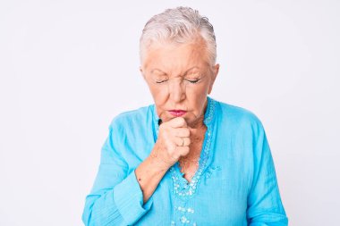 Mavi gözlü, gri saçlı, yaz kıyafetleri giyen, kendini iyi hissetmeyen ve soğuk algınlığı veya bronşitin belirtisi olarak öksüren son sınıf güzeli bir kadın. sağlık hizmeti kavramı. 