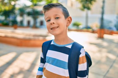 Kafkasyalı bir öğrenci parkta mutlu bir şekilde gülümsüyor..