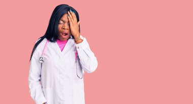 Genç Afro-Amerikan kadın doktor steteskobu takıyor. Yarı yüz, göz ve ağız kaplamasından yorulmuş. Yüzüm acıyor.. 