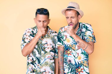 Yaz şapkası ve Hawaii gömleği giyen iki genç eşcinsel adam kendilerini kötü hissediyorlar ve soğuk algınlığı veya bronşitin belirtisi olarak öksürüyorlar. sağlık hizmeti kavramı. 