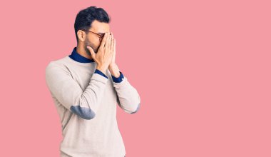 Zarif kıyafetler giyen ve ağlarken yüzünü ellerle kapatan üzgün yüzlü gözlüklü yakışıklı İspanyol bir adam. depresyon kavramı. 