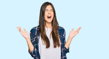 Genç esmer kadın gündelik giysiler giyip başarının çılgınlığını kutluyor. Kollarını kaldırmış, gözlerini kapatmış heyecanlı çığlıklar atıyor. Kazanan konsept 