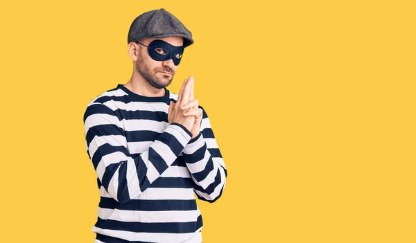 Young Handsome Man Wearing Burglar Mask Holding Symbolic Gun Hand — Stock Photo, Image