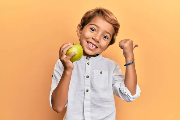 Förtjusande Latinunge Som Håller Grönt Äpple Pekande Tumme Upp Till — Stockfoto