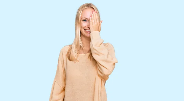 Młoda Blondynka Nosi Luźne Ubrania Obejmujące Jedno Oko Ręki Pewny — Zdjęcie stockowe