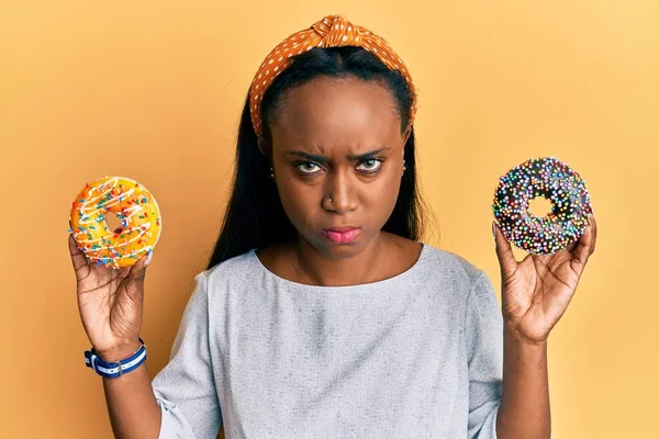 Jonge Afrikaanse Vrouw Met Smakelijke Kleurrijke Donuts Sceptisch Nerveus Fronsend — Stockfoto