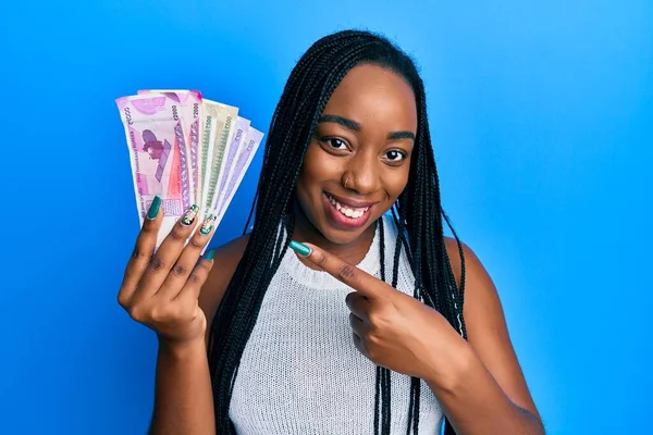 Joven Mujer Afroamericana Sosteniendo Billetes Rupias Indias Sonriendo Feliz Señalando —  Fotos de Stock