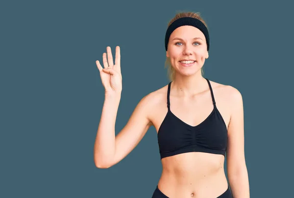 Genç Güzel Sarışın Kadın Spor Giysisi Giyer Parmaklarıyla Dört Numarayı — Stok fotoğraf