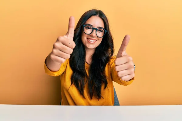 Hermosa Morena Joven Con Gafas Ropa Casual Sentada Mesa Aprobando — Foto de Stock