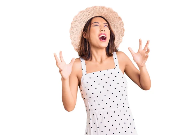 若い美しい中国の女の子は 夏の帽子クレイジーで狂気の叫びと積極的な表現と腕を上げて叫んでいます フラストレーションコンセプト — ストック写真