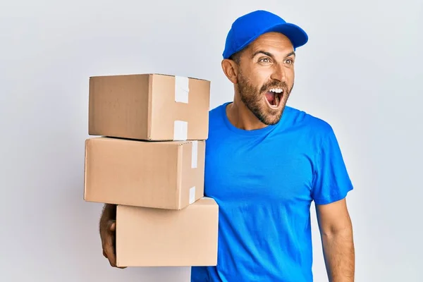 Handsome Man Beard Wearing Courier Uniform Holding Delivery Packages Angry — Stock Photo, Image