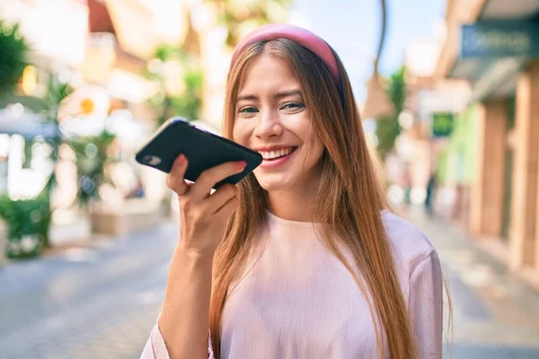 Jovem Caucasiana Sorrindo Feliz Enviando Mensagem Áudio Usando Smartphone Cidade — Fotografia de Stock