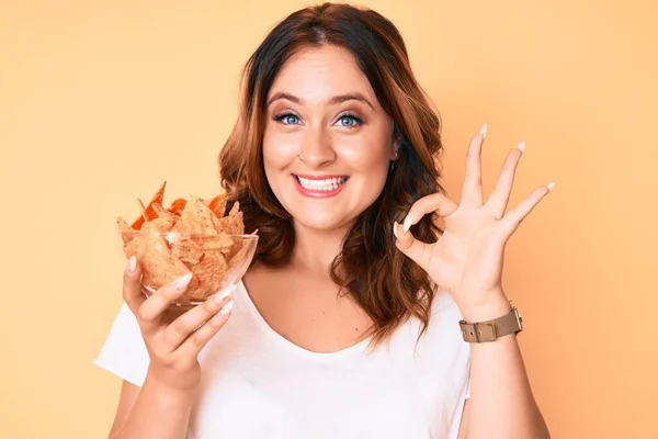 Jovem Bela Mulher Caucasiana Segurando Nachos Batatas Fritas Fazendo Sinal — Fotografia de Stock