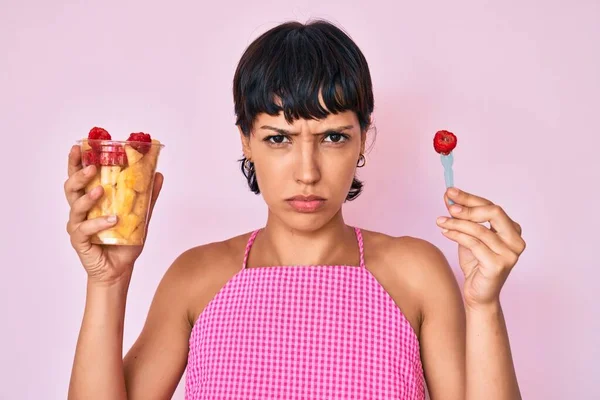 Piękna Kobieta Brunetka Jedząca Świeże Zdrowe Owoce Sceptyczne Nerwowe Marszczenie — Zdjęcie stockowe